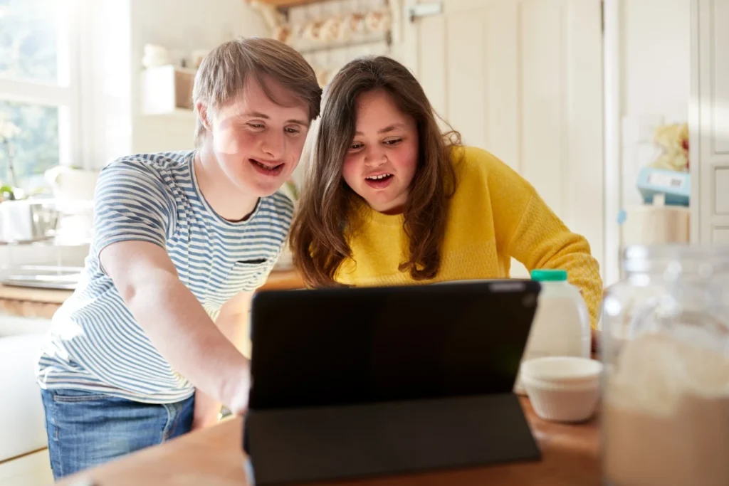 Two disabled friends with down syndrome looking at iPad together